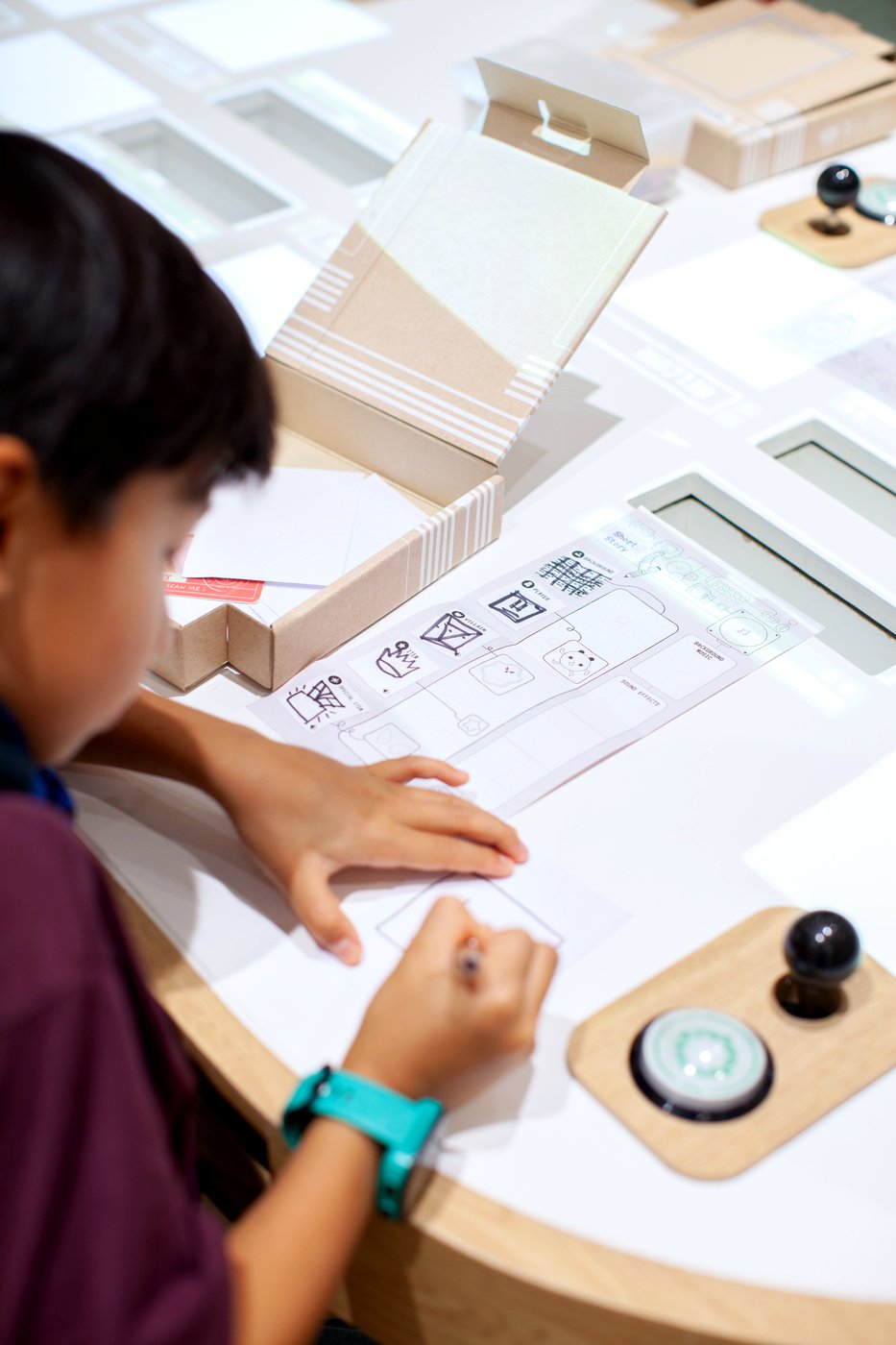 A child drawing their game character at the Gametory Arcade design table, CentralWorld